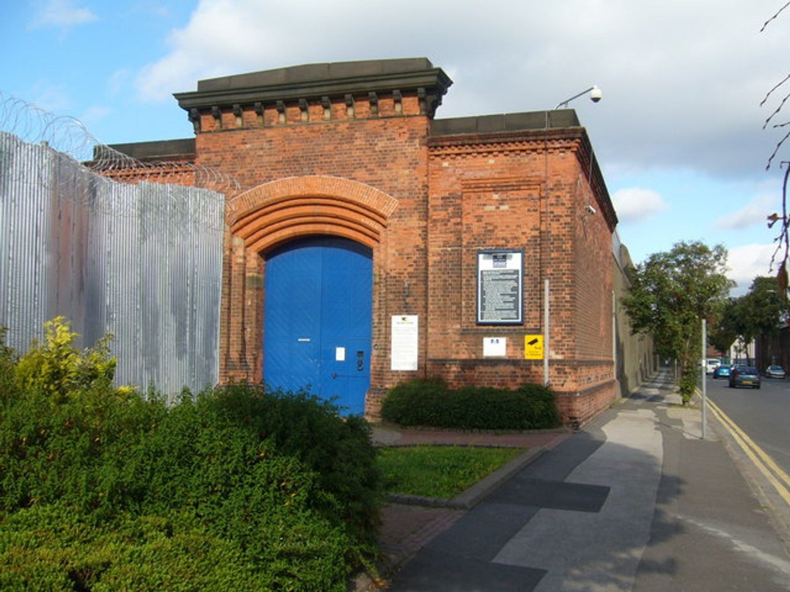 Old entrance of Nottingham Prison with the high perimeter wall extending beside the gate.