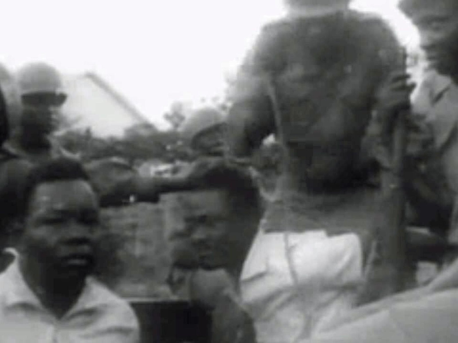 Patrice Lumumba under guard in a black-and-white December 1960 newsreel frame after his recapture.