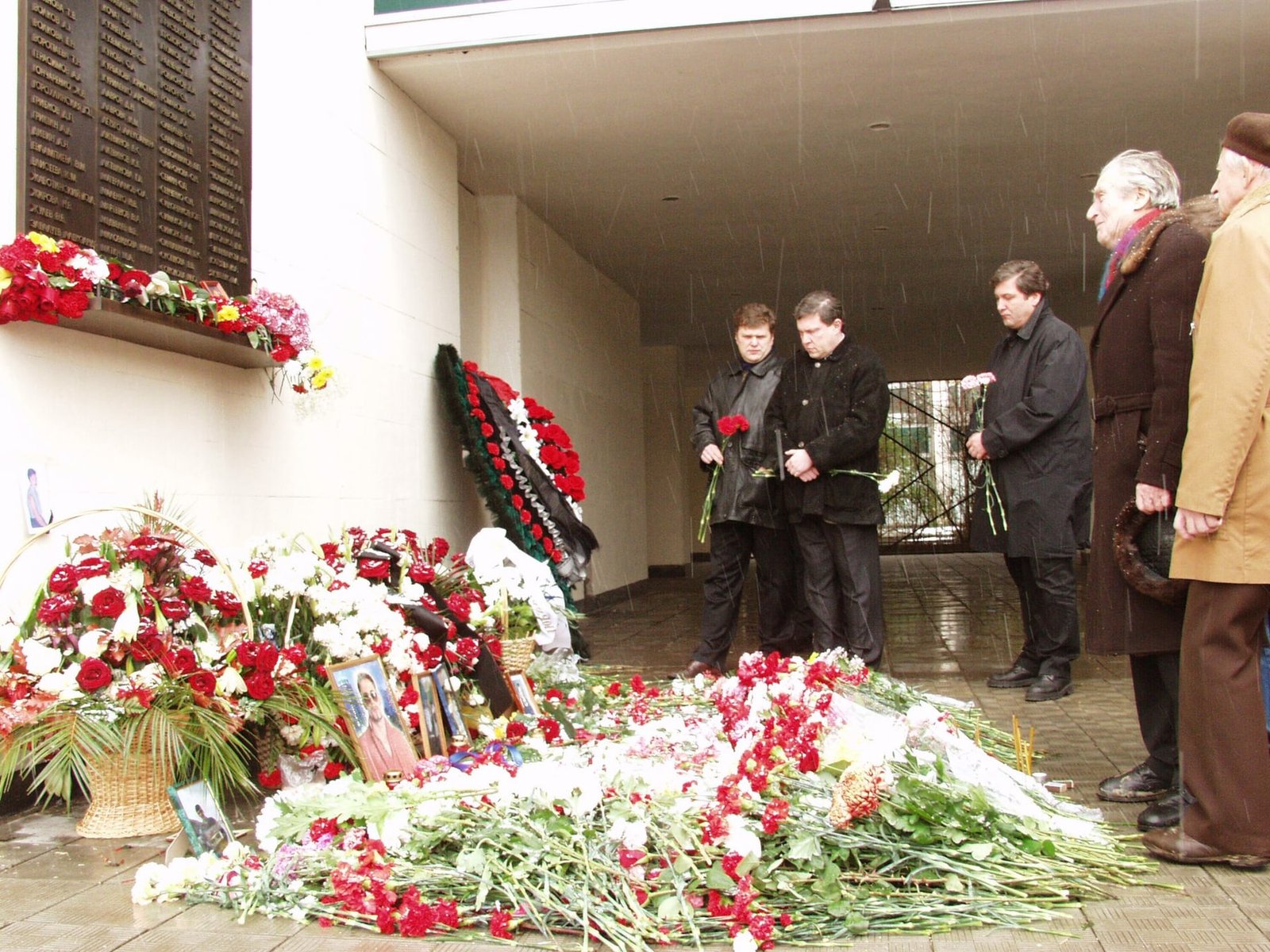 People laying flowers at the Nord-Ost memorial at the Dubrovka Theater Center in Moscow on October 26, 2003.