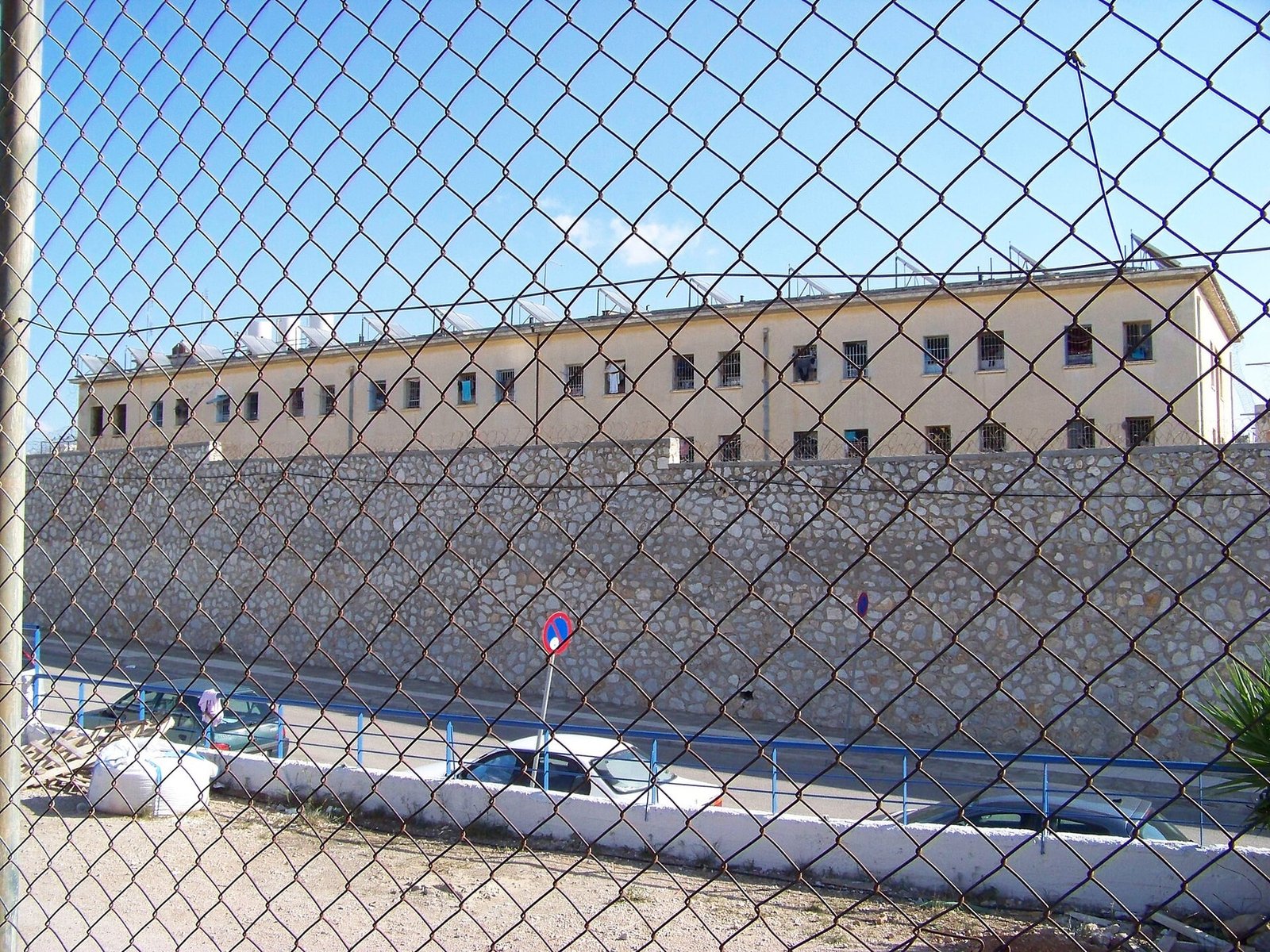 Exterior of Korydallos Prison in Greece, photographed in 2007 behind a chain-link fence.